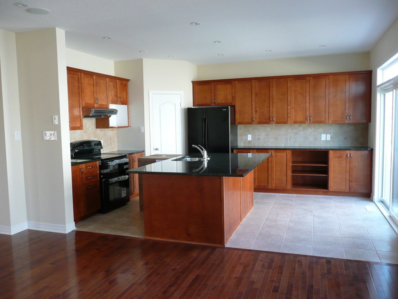 Kitchen island with a black granite worktop and an integrated sink