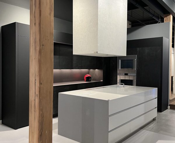 Showroom kitchen with matt black tall units and a pale grey island