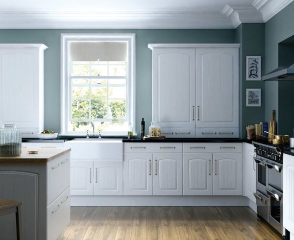 White shaker kitchen units with a dark worktop and grey-green walls